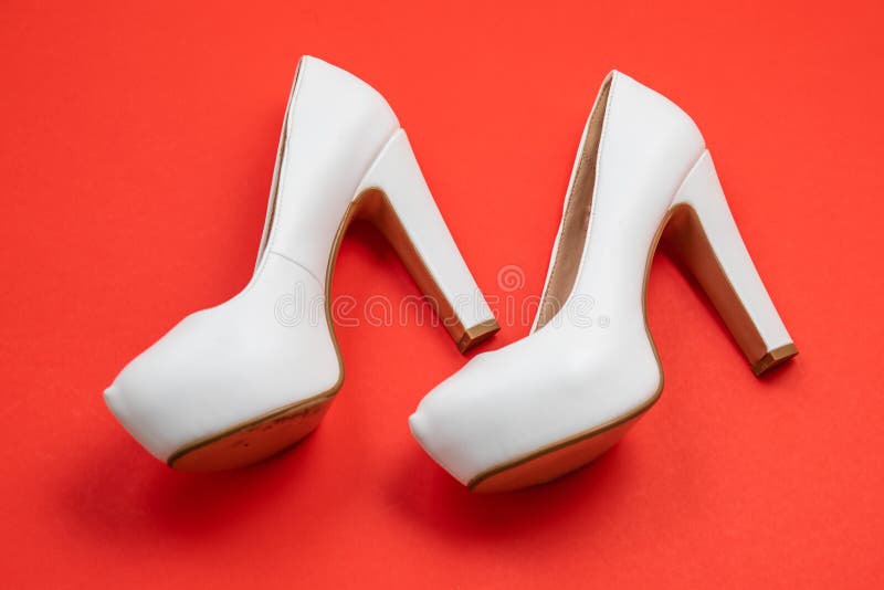 White high heeled shoes, red background - top view concept - heels walking left stock photo White high heeled shoes, red background - top view concept - heels walking left stock photo