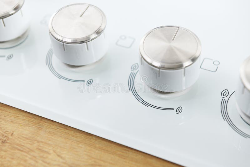 White Hob Glass Gas Panel with Integrated Controls. Closeup Adjustment