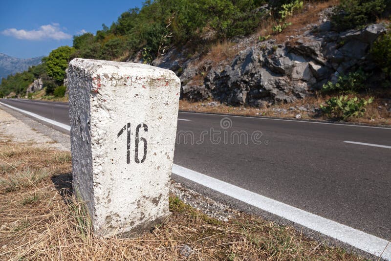 White kilometer stone post on the roadside