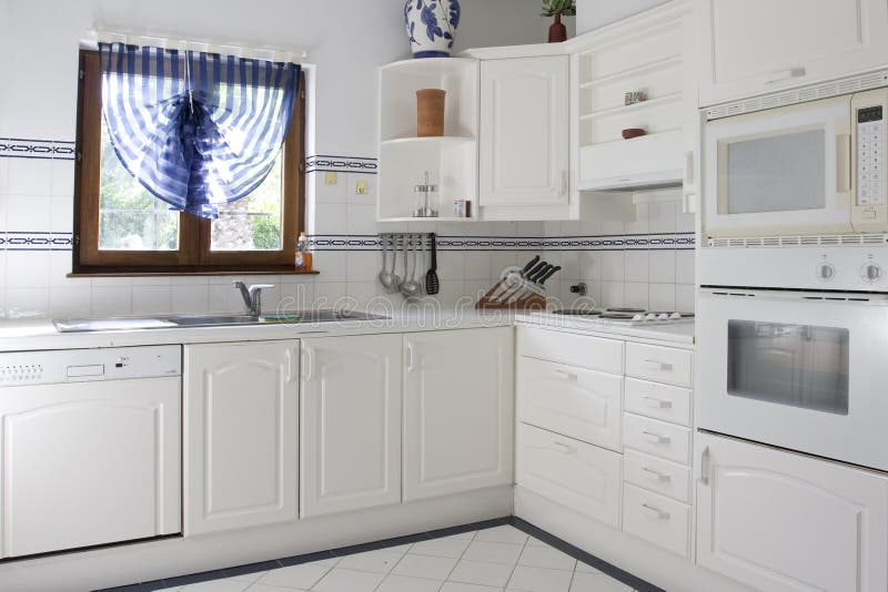 Cucina classica bianca in legno e piastrelle bianche.