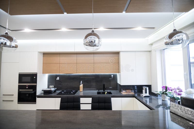 White Kitchen with Island, Table and Chairs. Kitchen Interiors Stock