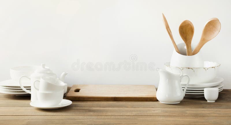 White kitchen utensils, dishware and other different white stuff for serving on white wooden board.