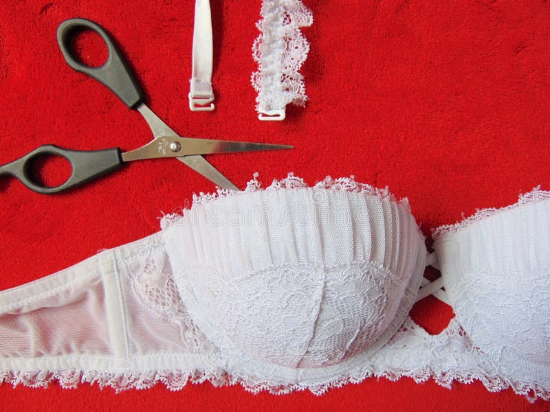White Lace Strapless Bra with Scissors Cutting the Straps Stock Photo