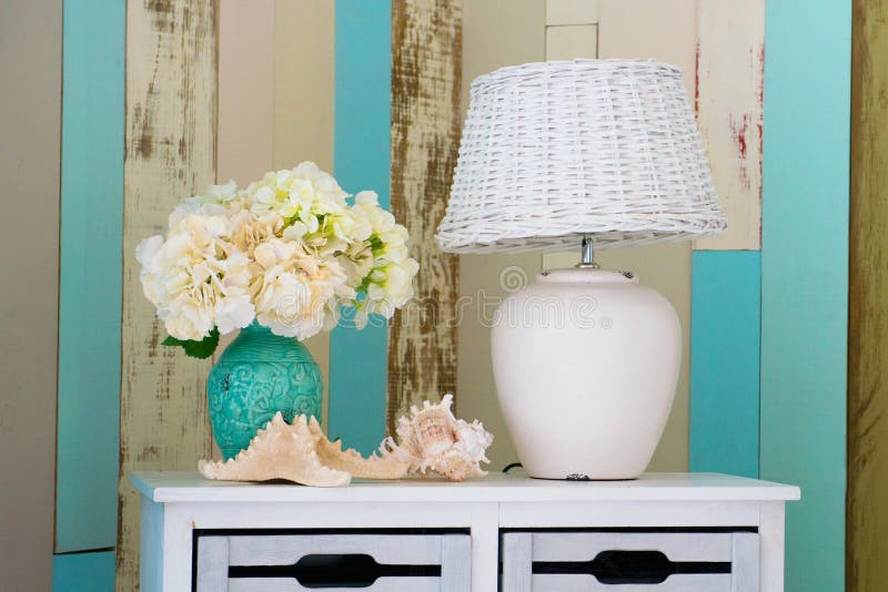 A White Lamp And A Vase Of Flowers Stand On The Nightstand Stock Image