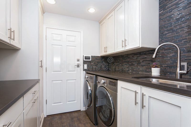 White laundry room boasts white shaker cabinets royalty free stock photos White laundry room boasts white shaker cabinets royalty free stock photos