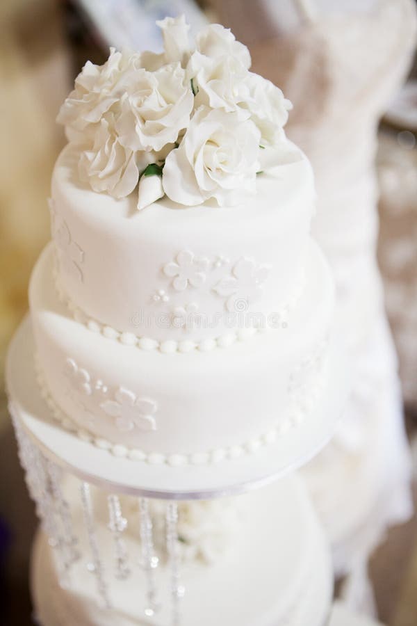 White layered wedding cake with roses on top