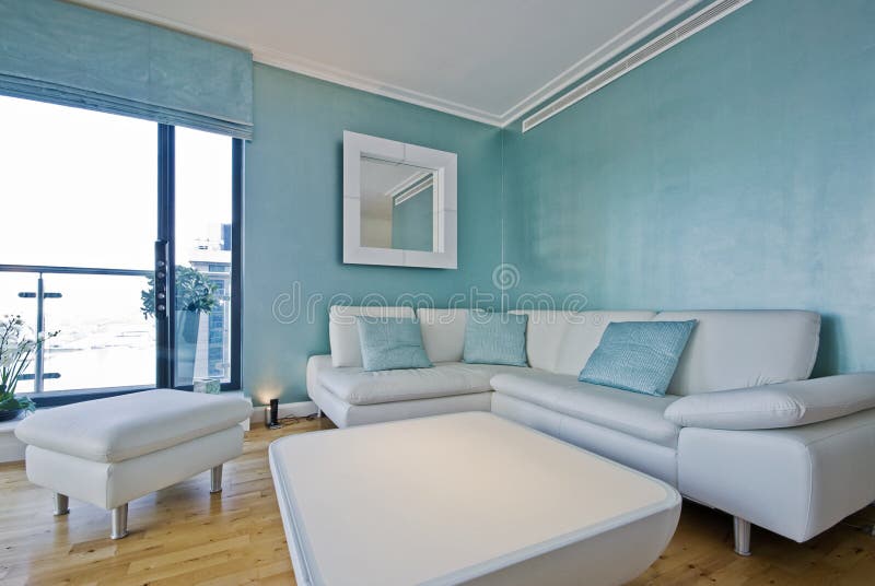 Weiß italienischen Leder-sofa in einem hellen blau-designer-Wohnzimmer mit Hintergrundbeleuchtung Tisch und Dekorative Elemente.