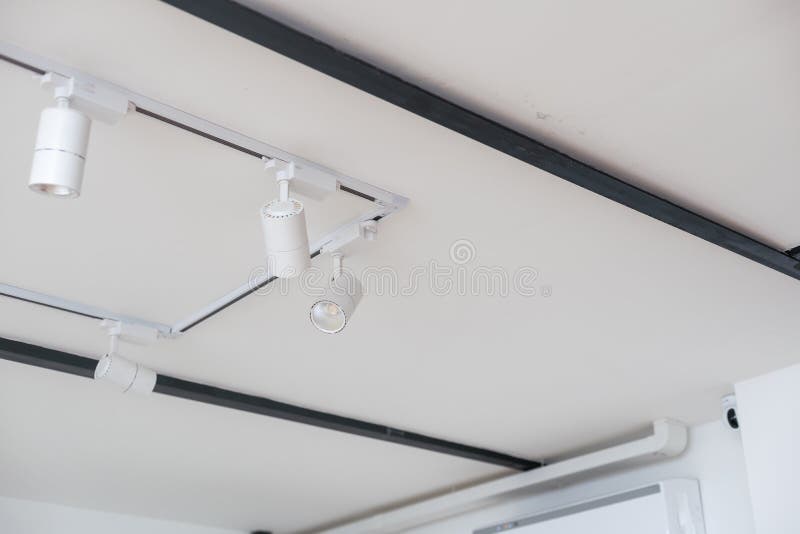 White led spotlight standing in white background. the system runs suspended from the ceiling on the rail. The head of stock photography