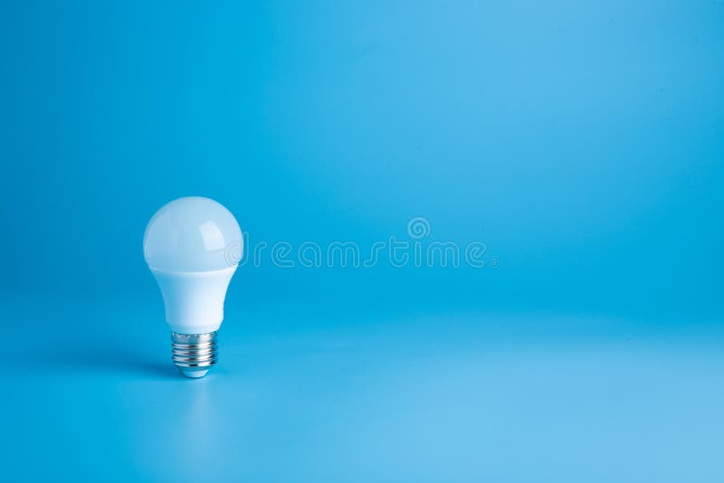 White light bulb on blue background in pastel colors. Bright idea concept