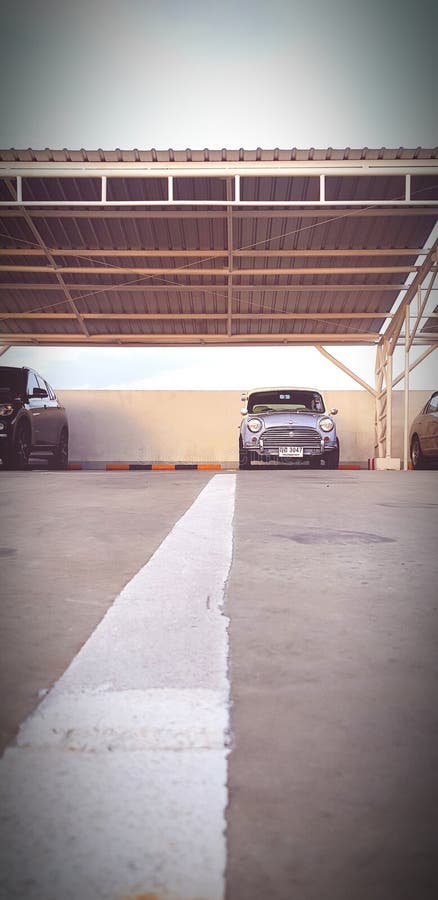 Bangkok, Thailand - July 20, 2019: White line road up to Blue classic Mini cooper car parked inside garage in vintage tone and Selective focus - Old vehicle, Transportation, Low angle view