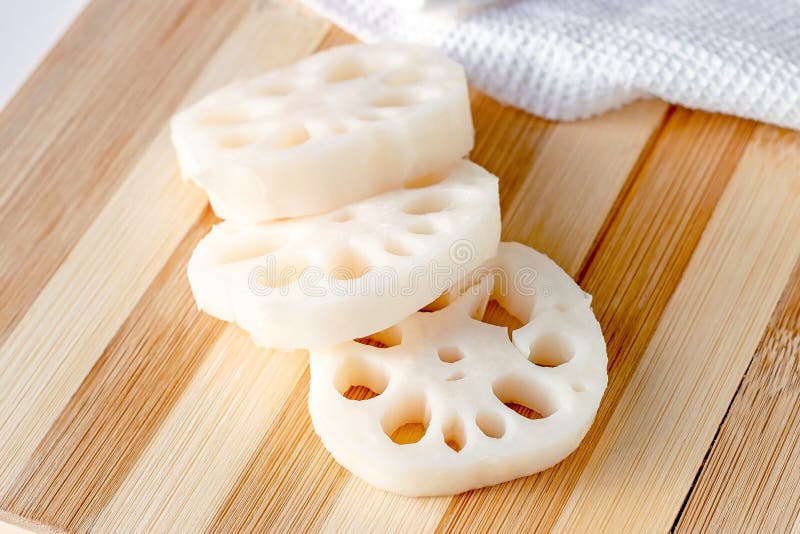 White lotus root (renkon) slices on the wooden cutting board in the kitchen close up. royalty free stock image White lotus root (renkon) slices on the wooden cutting board in the kitchen close up. royalty free stock image