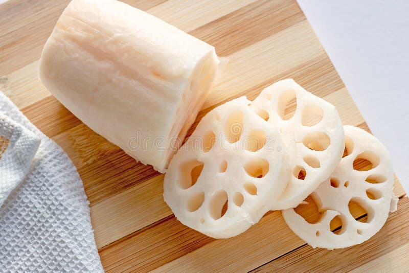 White lotus root (renkon) slices on the wooden cutting board in the kitchen close up. stock image White lotus root (renkon) slices on the wooden cutting board in the kitchen close up. stock image
