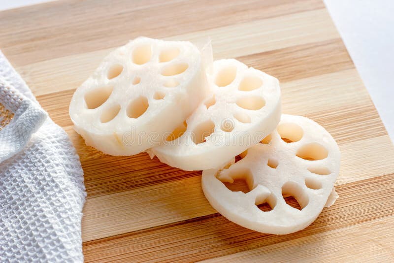 White lotus root (renkon) slices on the wooden cutting board in the kitchen close up. royalty free stock images White lotus root (renkon) slices on the wooden cutting board in the kitchen close up. royalty free stock images