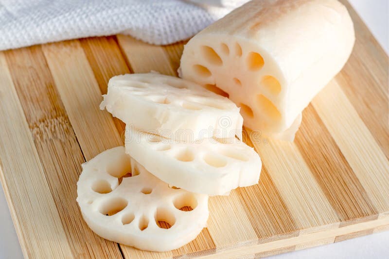 White lotus root (renkon) slices on the wooden cutting board in the kitchen close up. stock image White lotus root (renkon) slices on the wooden cutting board in the kitchen close up. stock image