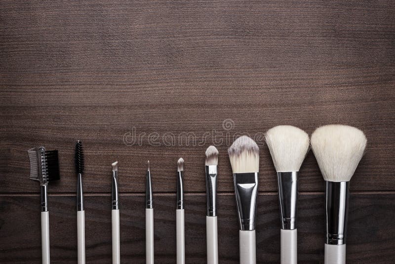White make-up brushes on wooden background