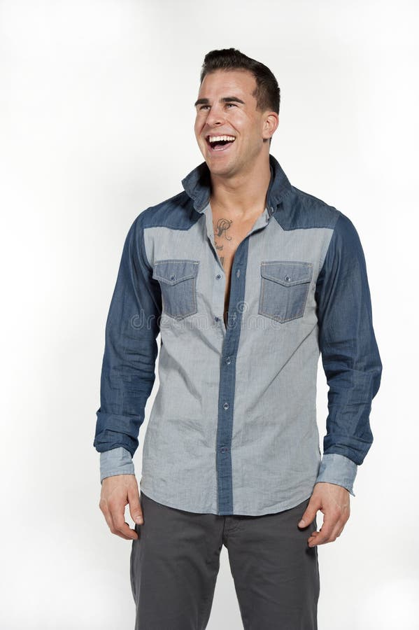 White Male in Jean Shirt and Gray Pants. Attractive white caucasian male model laughing while wearing a jean shirt and gray pants posing in a studio on a white stock photos White Male in Jean Shirt and Gray Pants. Attractive white caucasian male model laughing while wearing a jean shirt and gray pants posing in a studio on a white stock photos