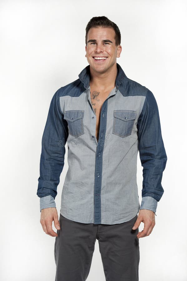 White Male in Jean Shirt and Gray Pants. Attractive white caucasian male model laughing while wearing a jean shirt and gray pants posing in a studio on a white stock photography White Male in Jean Shirt and Gray Pants. Attractive white caucasian male model laughing while wearing a jean shirt and gray pants posing in a studio on a white stock photography