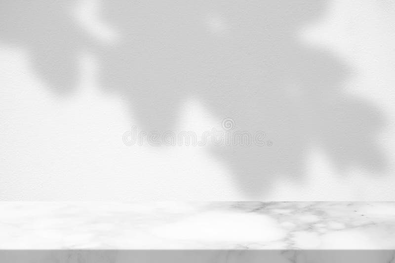 White Marble Table with Tree Leaves Shadow on Concrete Wall Texture Background. stock images