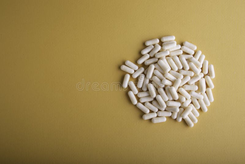 White Medicine Capsules on Orange Background. Stock Photo Image of
