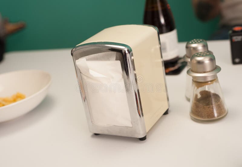 White, metal retro napkin dispenser, Salt and pepper shakers on a table