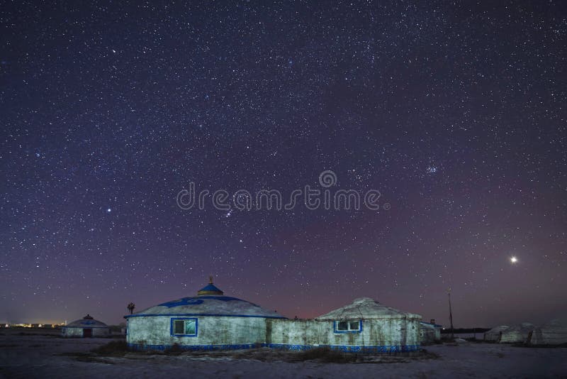 The white Mongolian yurts in night starry sky in winter