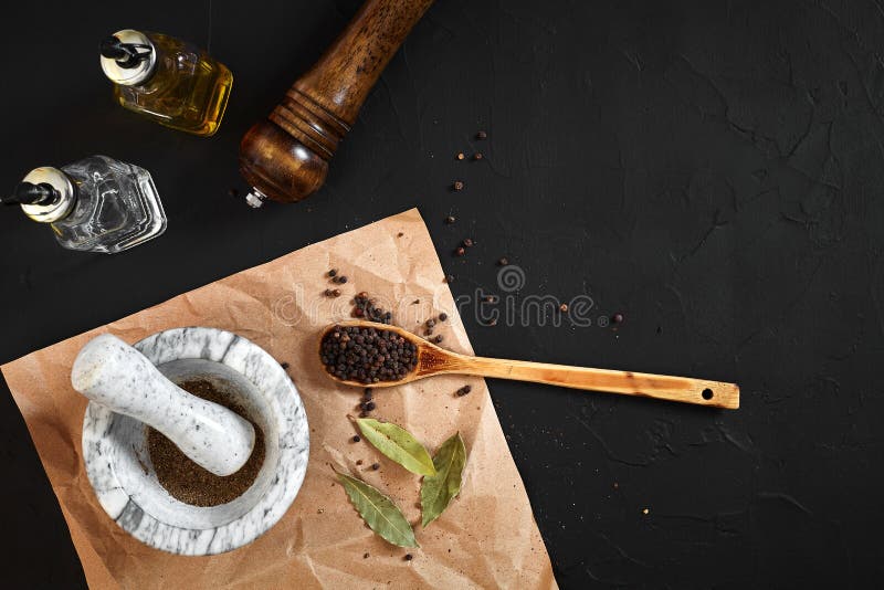 White mortar and pestle with dried peppers in flat lay on black background stock photos White mortar and pestle with dried peppers in flat lay on black background stock photos