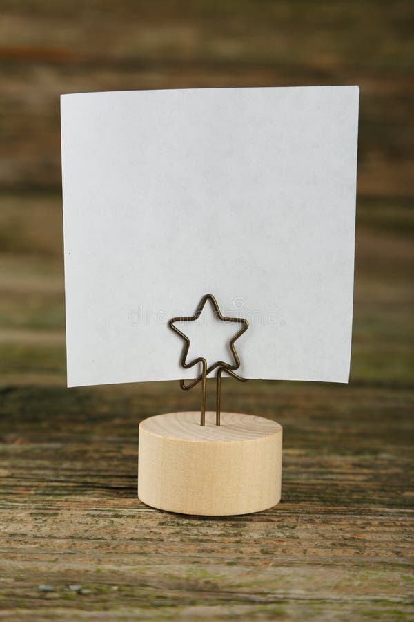 White note paper on a holder on a brown wooden background stock photos