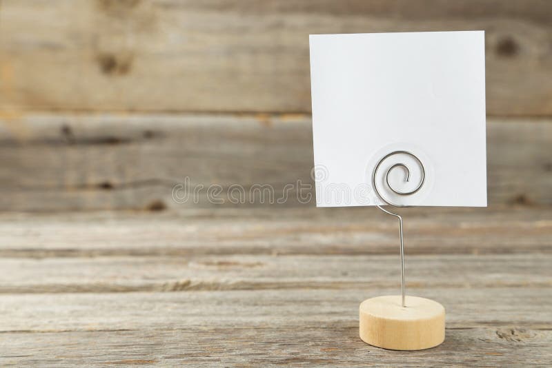 White note paper on a holder on grey wooden background. royalty free stock photos