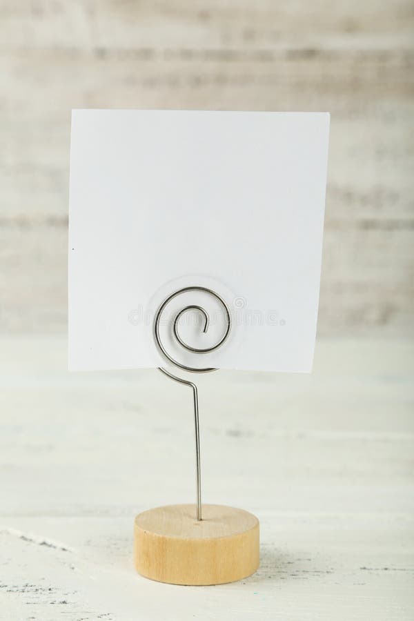 White note paper on a holder on white wooden background. stock photo