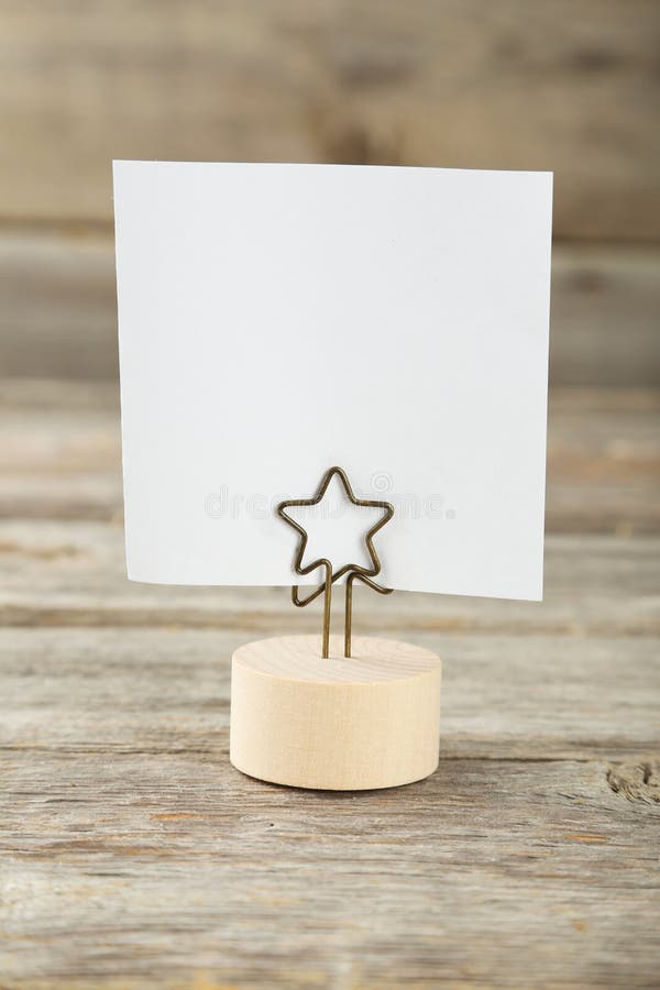 White note paper on a holder on wooden background stock image