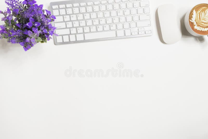 White office desk table with computer keyboard, mouse, and cup of coffee. Top view with copy space, flat lay stock photo