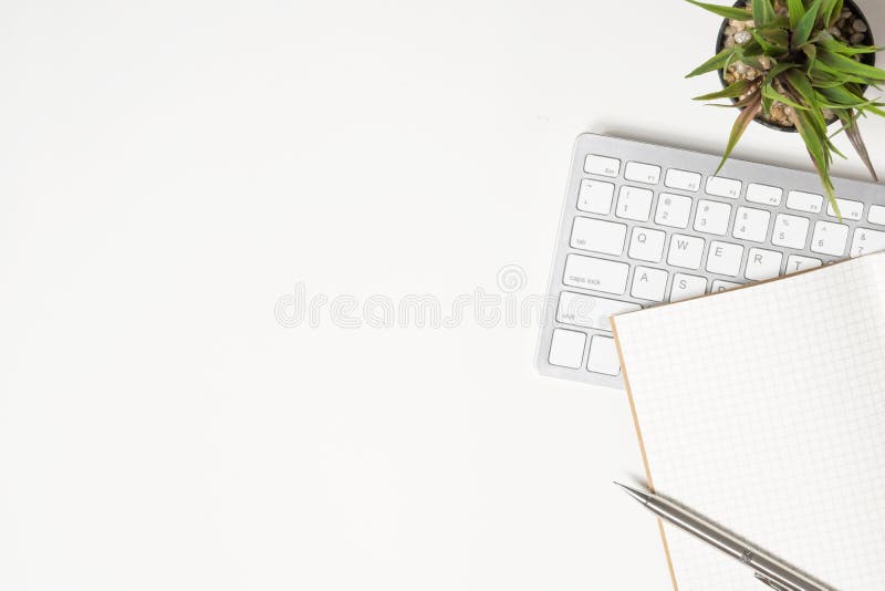 White office desk table with notebook, pen and computer keyboard royalty free stock photos