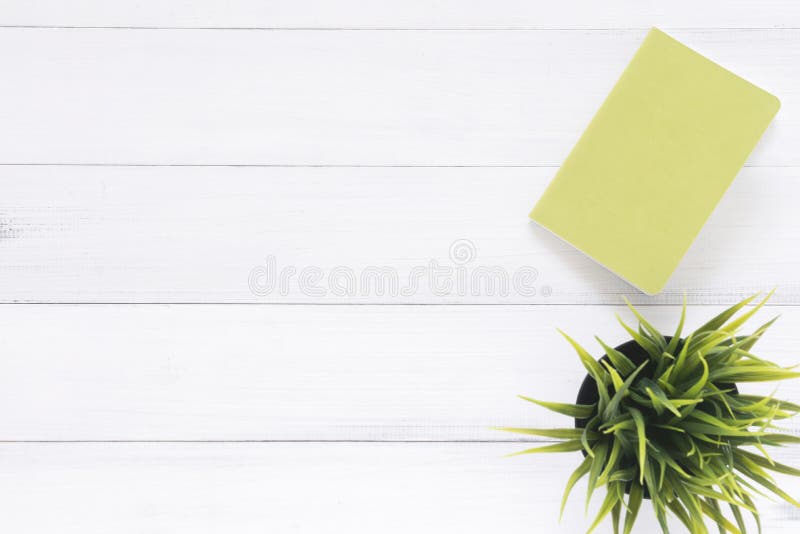 White office desk wooden table background with mock up notebooks and plant. Top view with copy space, flat lay photography.