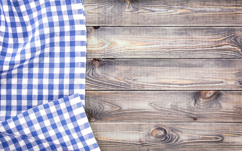 White old wooden table with blue checkered tablecloth, top view with copy space