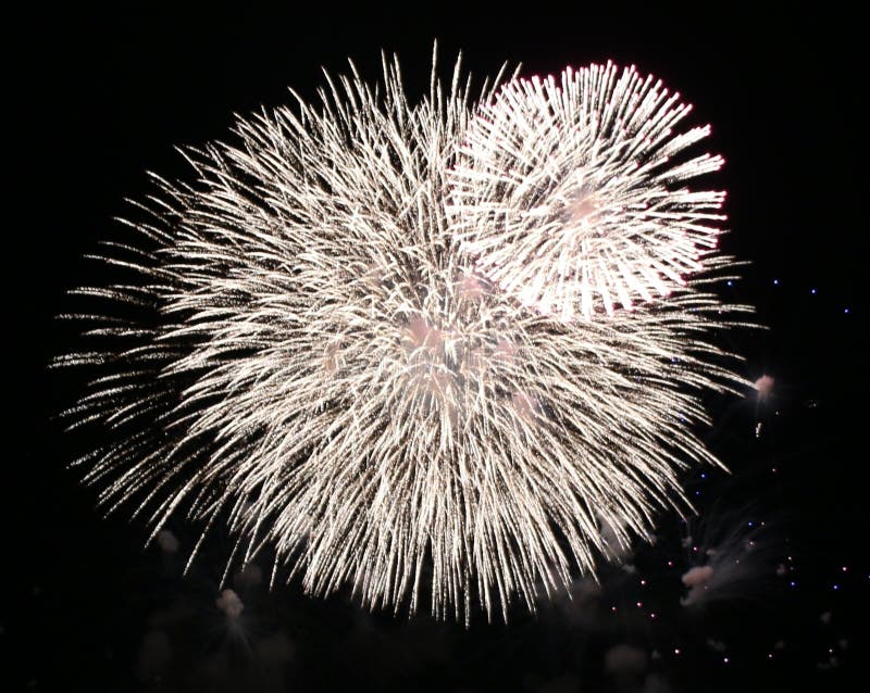 White overlapping fireworks against a dark night sky. Overlapping exploding fireworks stock images, royalty-free photos and pictures