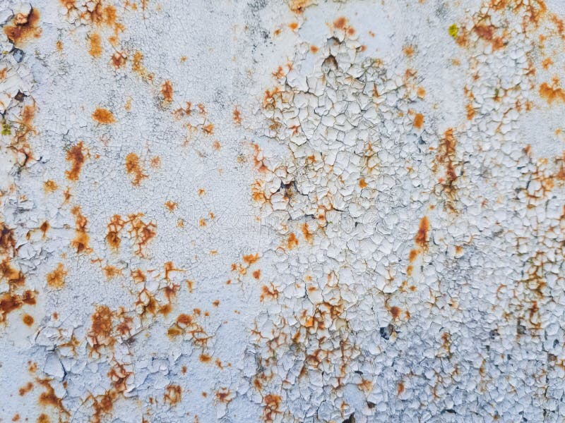 White paint peeling off on rusty metal. stock photography.