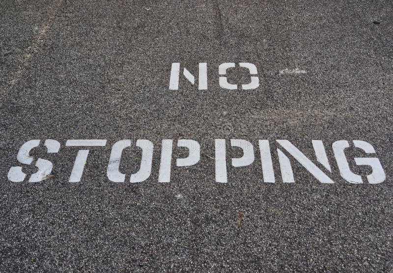 White No Stopping Sign Stenciled on Black Road