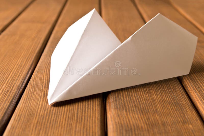 White paper airplane on wooden background. Travel concept royalty free stock photography White paper airplane on wooden background. Travel concept royalty free stock photography