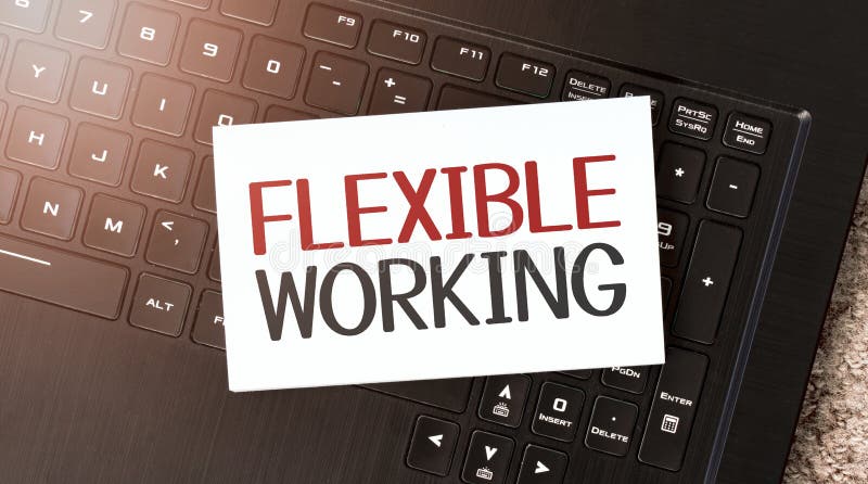 White paper sheet with text FLEXIBLE WORKING on the black laptop stock photo