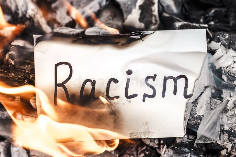 White paper with text of racism in fire. Concept of nationalism and ethnic equality. Social Issues. Discrimination, racial problem