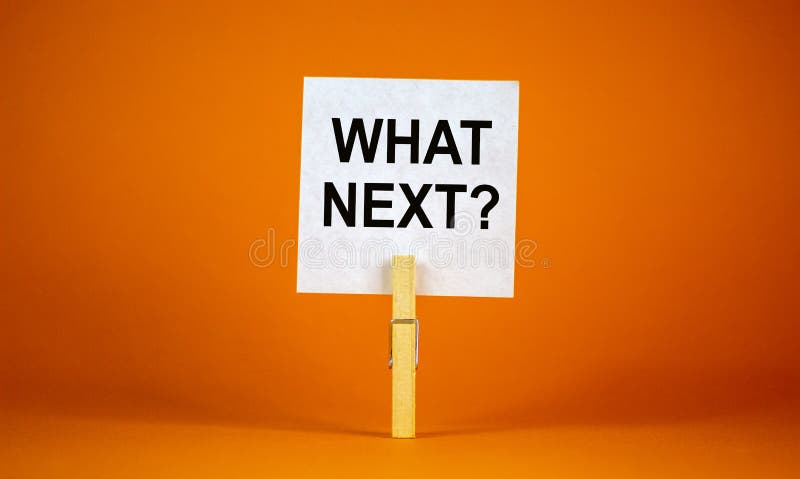 White paper with text `Whats next`, clip on wood clothespin. Beautiful orange background. Business concept. Copy space