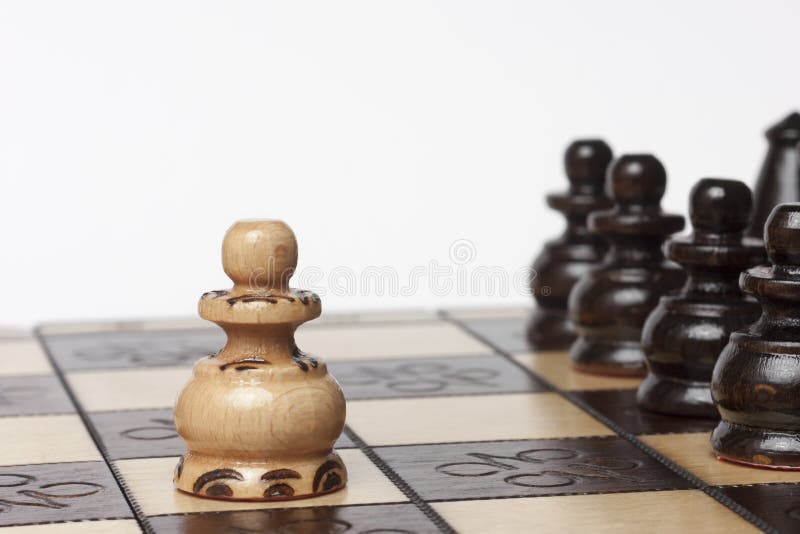 White pawn challenging army of black chess pieces