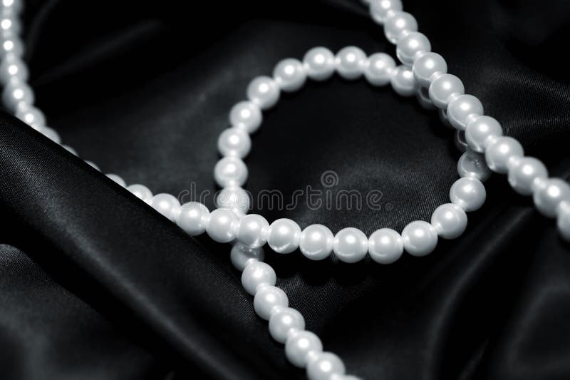 White pearls on the black silk background, Stock image