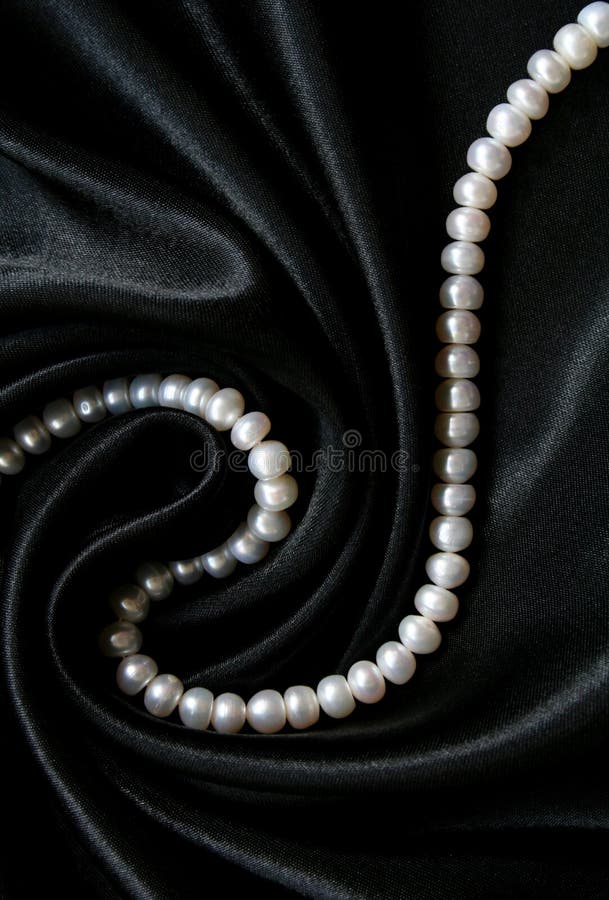 White pearls on the black silk background, Stock image