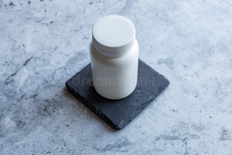 White Plastic Bottle for Medicine on a Stone Texture Stock Image
