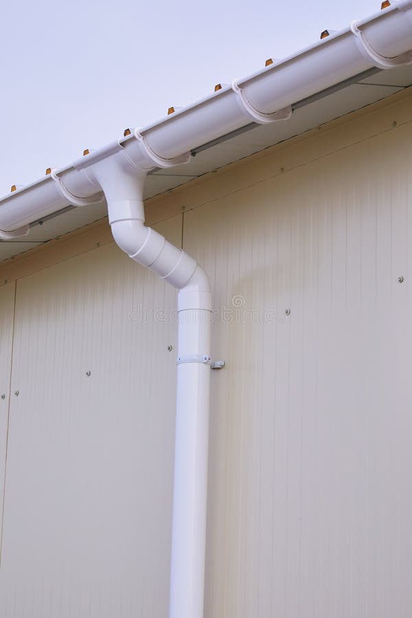 Plastic Rain Gutter with Two Downspout and Background Blue Sky. Plastic