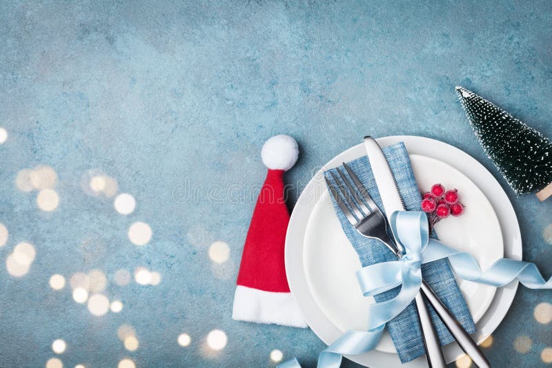 White plate and cutlery decorated santa hat and small fir tree. Christmas table setting from above. royalty free stock image White plate and cutlery decorated santa hat and small fir tree. Christmas table setting from above. royalty free stock image