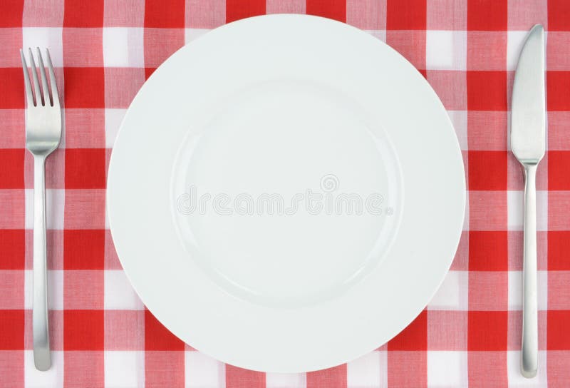 White plate on red and white checkered cloth stock photos