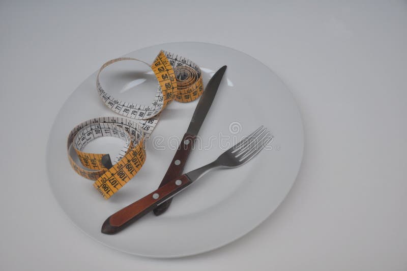 White Ceramic Plate with Yellow Measuring Tape, Fork and Knife on White