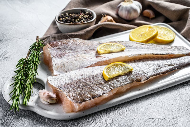 White raw fillet hake fish. White background. Top view